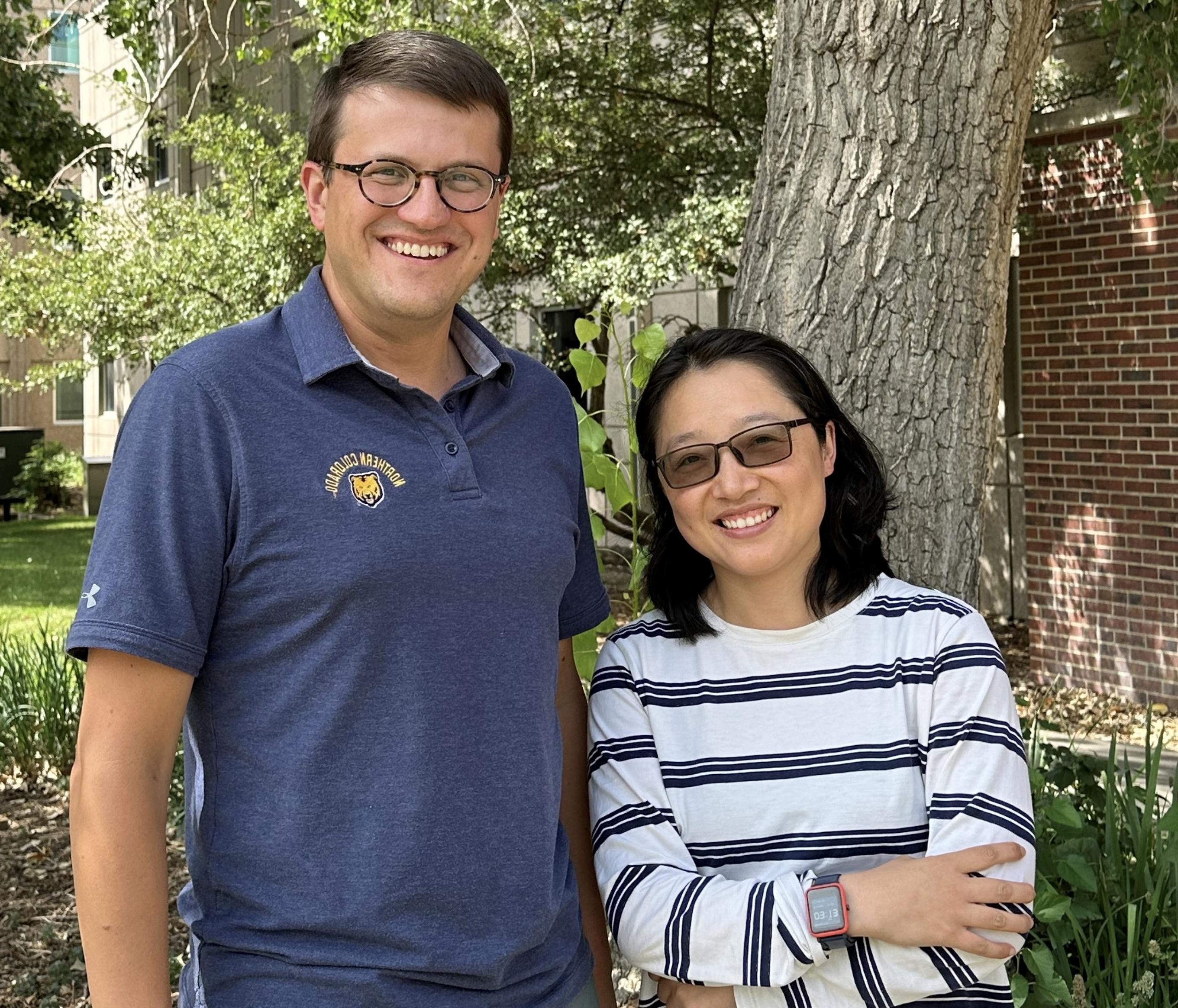 Yuyan Han and Nicholas Pullen Win pose for a photo in front of a tree.